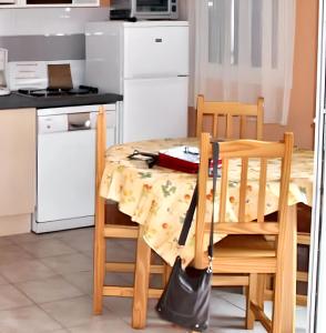 kuchnia ze stołem z obrusem w obiekcie Maison accueillante à Calvisson avec piscine et terrasse w mieście Calvisson
