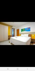 ein Schlafzimmer mit einem großen weißen Bett und einem Gemälde an der Wand in der Unterkunft APARTAMENTO OLIMPIA PARK RESORT 503 c in Olímpia + 34 Fotos