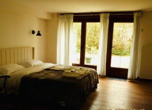 a bedroom with a bed and a large window at Iris Garden Cottage in Saint-Germain-en-Laye