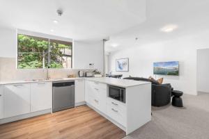 an open kitchen with white cabinets and a couch at Camperdown Cozy Corner 1 in Sydney
