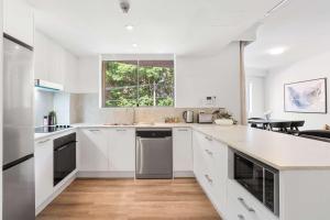 a kitchen with white cabinets and a window at Camperdown Cozy Corner 1 in Sydney +7 photos