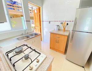 a kitchen with a stove and a refrigerator at Bella casa en Los Molles Nº3 a 8 min de la playa in Los Molles