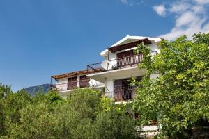 a white building with balconies and trees at Apartment Damir in Tučepi