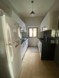 a kitchen with a white refrigerator and a wooden floor at The view stay in Baabda