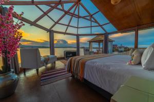ein Schlafzimmer mit Bett und Meerblick in der Unterkunft UROS KAY PACHA Lodge in Puno