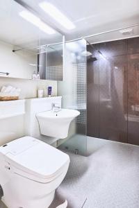 a bathroom with a toilet and a sink and a shower at Haeundae Beach Bexco in Busan