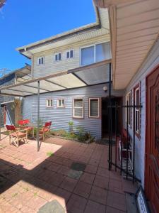 a house with a patio with a table and chairs at Hostal Puerto Varas in Puerto Varas