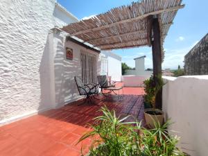 a patio with two chairs and a pergola at El depto de Bowie in Santa Rosa de Calamuchita