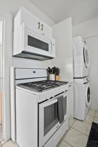 a white kitchen with a stove and a microwave at Draper Bungalow By CoastVH - Charming 1940 in San Diego +20 photos