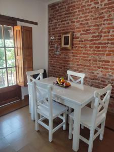a white table and chairs with a plate of fruit on it at El depto de Bowie in Santa Rosa de Calamuchita