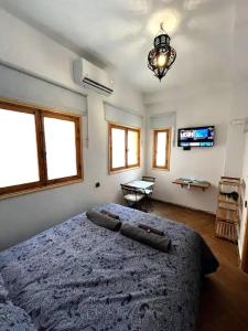 a bedroom with a large bed and a chandelier at Entire Studio Steps From The Kasbah Museum In The Ancient City in Tangier