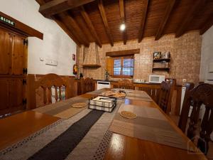 a kitchen with a large wooden table in a room at El Desván del Trigo in El Barraco +19 photos