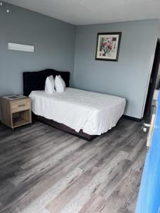 Un dormitorio con una cama y suelo de madera. en Motel 10, en Lordsburg