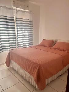 1 dormitorio con 1 cama con edredón de naranja y ventana en Casa de temporada imperatriz ma, en Imperatriz