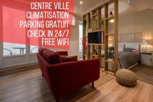 een woonkamer met een rode stoel en een bed bij La Dolce Vita in Châtel-Guyon