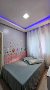 una camera da letto con letto con testiera rosa e tende di Duda House com piscina aquecida a Penha