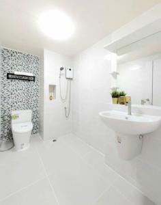 a white bathroom with a sink and a toilet at Impact poppula P1 by เจี๊ยบ in Thung Si Kan