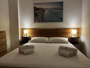 a bedroom with a large white bed with two lamps at ONDA BLU-Appartamenti in Torre dell'Orso