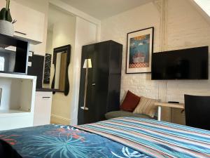 a bedroom with a bed and a flat screen tv at Equilibrium Family House by E in Roubaix