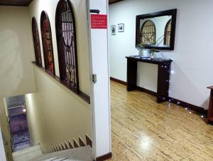 a hallway with a room with a mirror and a table at Hotel Alpino Armenia in Armenia