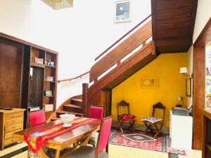 モンテビデオにあるHabitación single en Casa Art Deco en Barrio Surの黄色の壁のダイニングルーム(テーブル付)