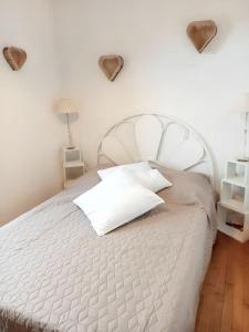 a white bed with two pillows on it in a bedroom at Maison charmante à Lavercantière avec piscine partagée in Lavercantière