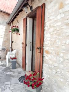 a building with flowers in front of a door at Maison charmante à Lavercantière avec piscine partagée in Lavercantière