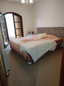 a large bed in a bedroom with a window at Apto 2 quartos em Capivari - Campos do Jordão in Campos do Jordão