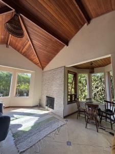 a living room with a fireplace and a table and chairs at Casa condomínio perto Animália in Vargem Grande Paulista