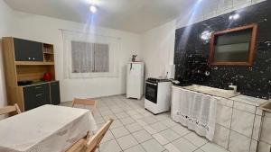 a kitchen with a refrigerator and a table in it at Kitnet nas Montanhas in Campos do Jordão