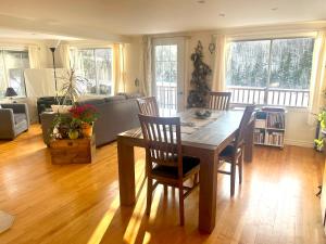 een woonkamer met een houten tafel en stoelen bij Chalet du lac long in Saint Come