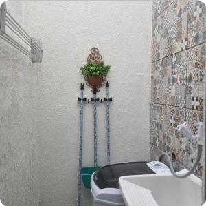 ein Badezimmer mit Toilette und einer Pflanze an der Wand in der Unterkunft Sulacap Dulce Recanto in Rio de Janeiro