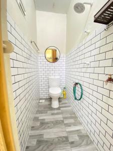 a bathroom with a toilet and white subway tiles at Homestay Tanjung Malim DMalim in TanjongMalim