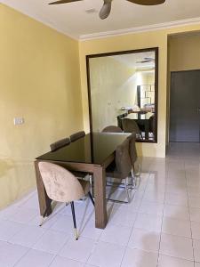 a dining room table with chairs and a mirror at Homestay Tanjung Malim DMalim in TanjongMalim