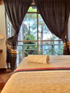 a pillow on a bed in a room with a window at Axkan Arte Hotel in San Cristóbal de Las Casas