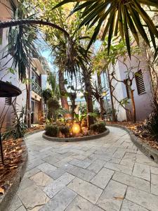 a courtyard with palm trees and a stone walkway at Axkan Arte Hotel in San Cristóbal de Las Casas