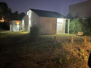 a house at night with a bench in the yard at Cabañas del monte in Monte Hermoso