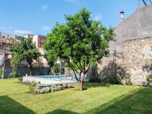 a tree in a yard next to a building at Apartment near Mount Etna with Pool in Giarre +29 photos