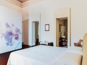 a bedroom with a white bed and a painting on the wall at Apartment in Giarre near Mount Etna in Giarre