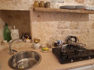 een aanrecht met een wastafel en een fornuis bij Holiday Home Trullo Antico in Ostuni +66 foto's