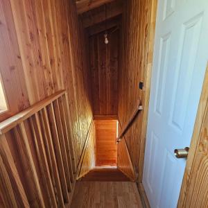 a hallway with wooden walls and a wooden stairway at Cabañas Los Arrayanes in Licán Ray