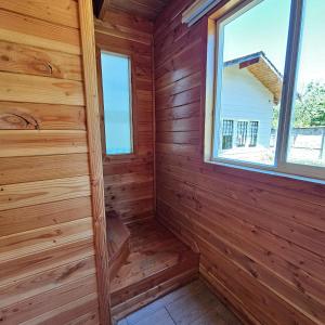 a wooden room with a window in a log cabin at Cabañas Los Arrayanes in Licán Ray