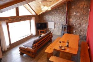 a dining room with a wooden table and a couch at Cabañas El Legado in Los Molles