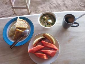 a table with two plates of food and a cup of coffee at DANG dang Balbago Beach in El Nido