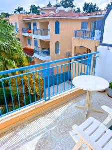 a balcony with a table and chairs and a building at Paradise Gardens Cozy Oasis with AC, WIFI, and pool in Paphos City +44 photos
