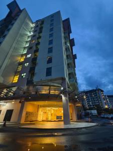 哥打京那巴鲁South China Sea Place by Kinabina Homestay的一座高大的建筑,前面有一个停车位