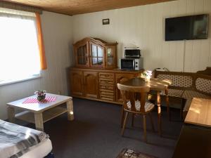a room with a bed and a table and a kitchen at Kleines Haus am Wald in Benshausen