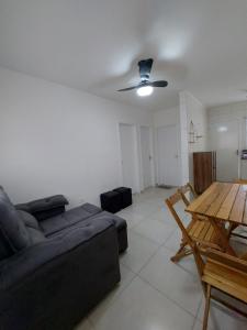 ein Wohnzimmer mit Sofa und Tisch in der Unterkunft Boracéia Appartamento garaje & funcionalidade in Bertioga
