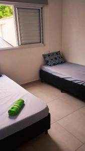 ein Zimmer mit zwei Betten und einem Fenster in der Unterkunft Boracéia Appartamento garaje & funcionalidade in Bertioga
