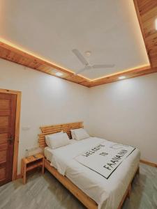 a bedroom with a bed with a sign on it at Faana Inn in Fulhadhoo +19 photos